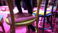 An Invisible Orchestra production photo. A close-up of a small child's feet on a pink mat on a yellow chair.