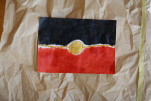 Aboriginal flag artwork against parchment paper, 2023.