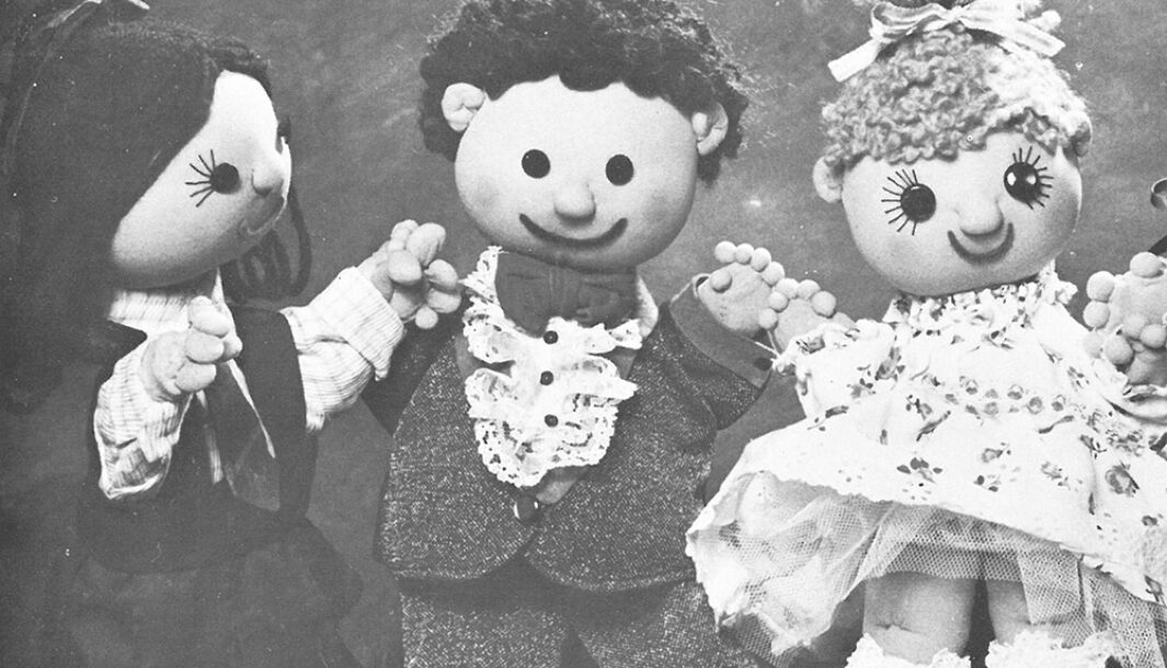 A Polyglot Puppet Theatre production image of 'The Good Friends'. Three puppets, two with brown hair, one with blonde hair, are pictured. They all have smiles and button eyes.