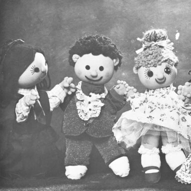A Polyglot Puppet Theatre production image of 'The Good Friends'. Three puppets, two with brown hair, one with blonde hair, are pictured. They all have smiles and button eyes.