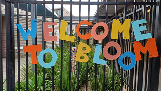A BLOOM photo. Colourful letters spell out 'Welcome to Bloom' on a black fence. Photo: Emily Tomlins