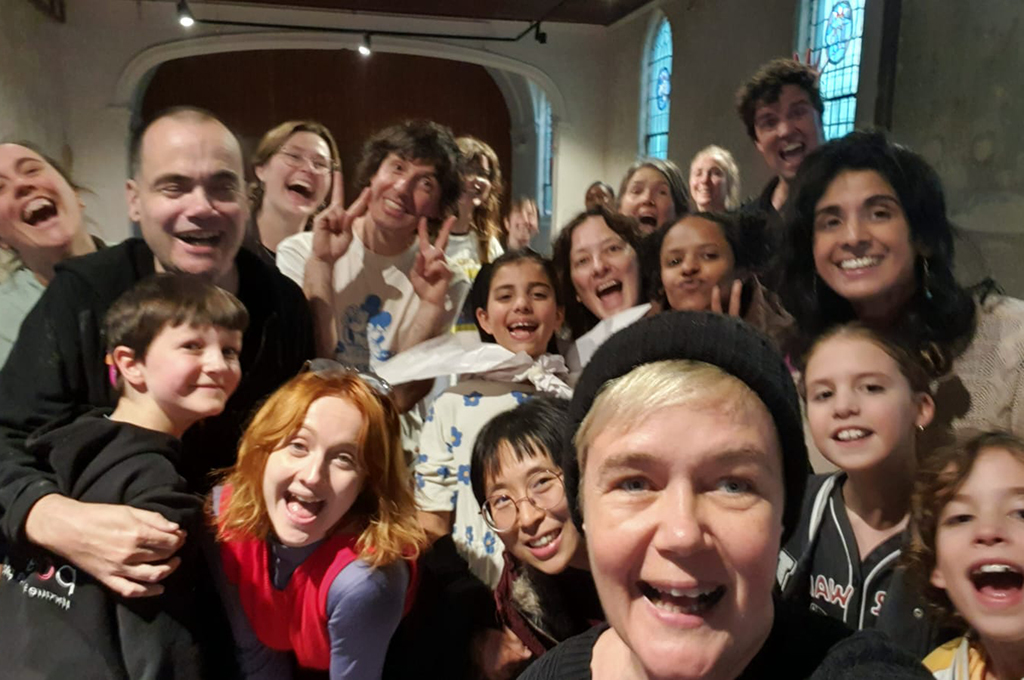 An Emily Tomlins selfie. Generator artists and PIPS gather together, smiling at the camera.