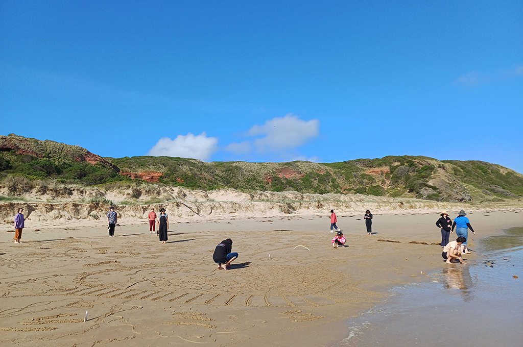 Polyglot artists move, explore and create across a beach. Photo: Cat Sewell. 