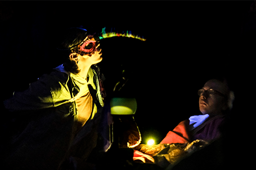 WTWT production photo: A Polyglot artist wears a costume beak and looks over a child. Photo: Suzanne Phoenix.