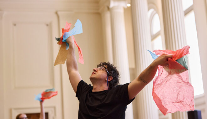 Whirlwind production photo: Laura May Grogan. Polyglot artists gracefully move through the performance space, holding colourful tissue paper.